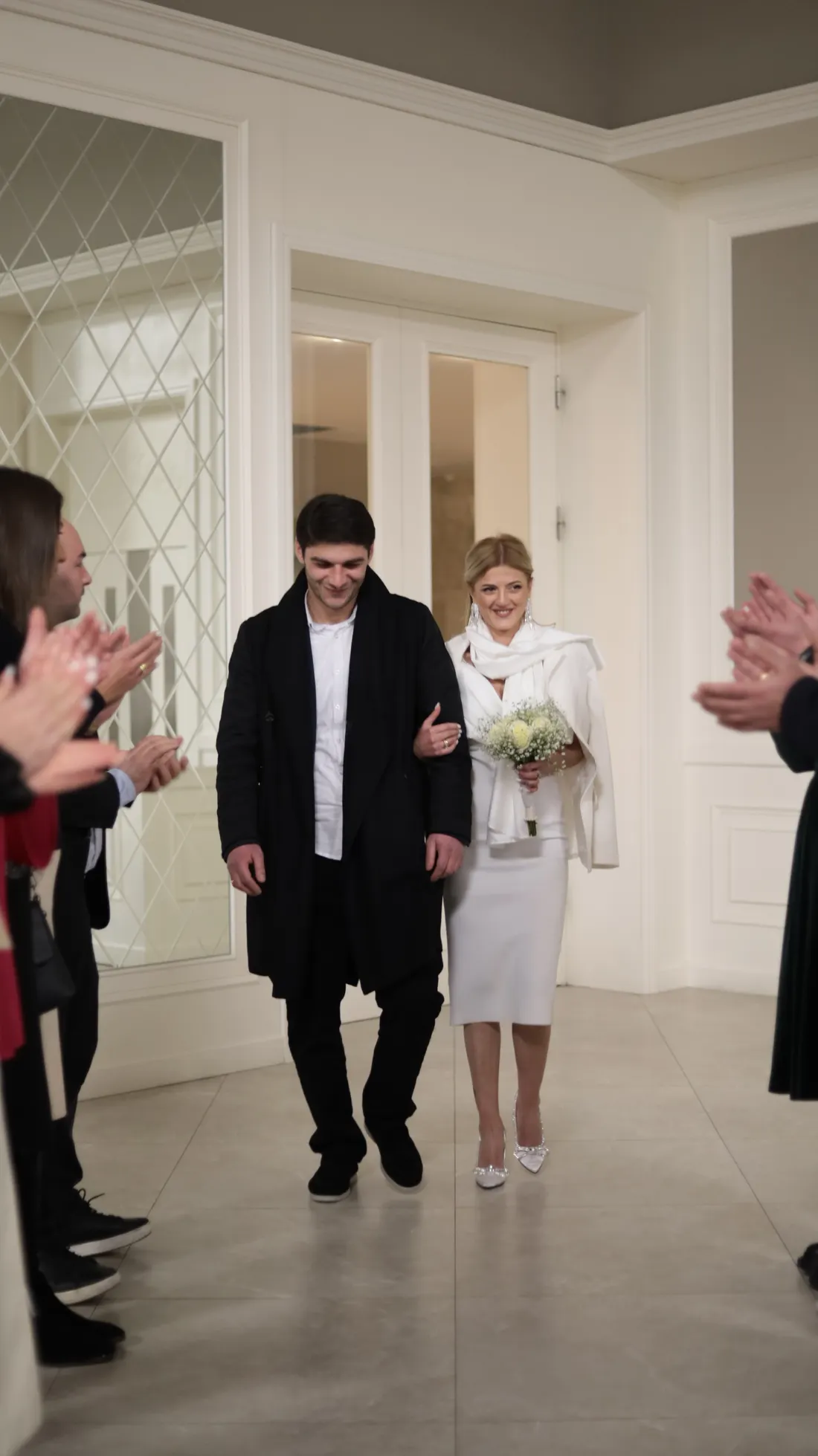 Una pareja recién casada sale del registro civil entre aplausos