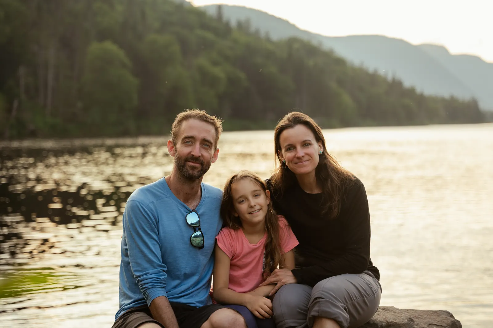 Una familia de vacaciones a orillas de un lago entre montañas